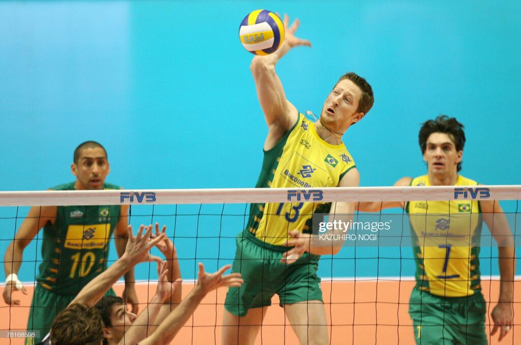 Brazilian attacker Gustavo Endres (C-#13) prepares to spike the ball against Argentina while his teammates, Gilberto Godoy Filho (R) and Sergio Dutra Santos (L-#10) look on during their match at the FIVB Men's World Cup volleyball tournament in Tokyo, 30 November 2007. Brazil beat Argentina 25-20, 25-22, 26-16.     AFP PHOTO / KAZUHIRO NOGI (Photo credit should read KAZUHIRO NOGI/AFP via Getty Images)